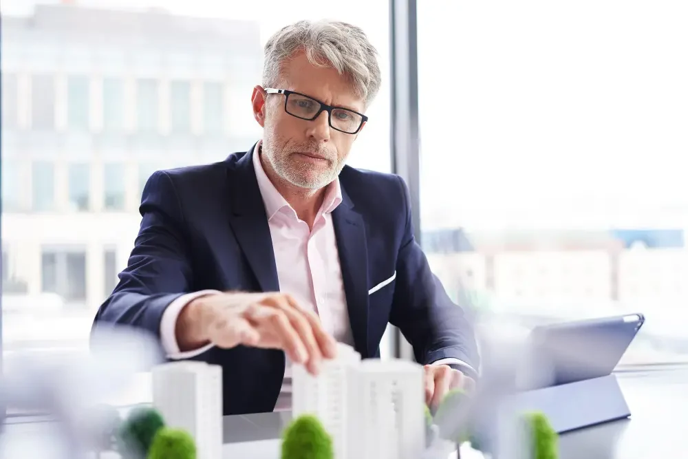 Un señor con canas y trajeado que es un asesor inmobiliario